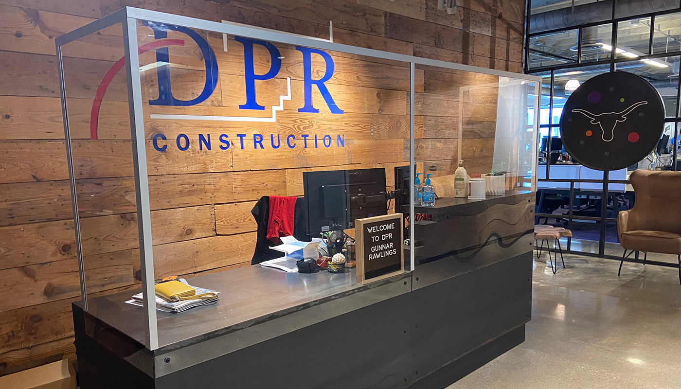 The reception desk at DPR Construction's Dallas office with a newly-installed barrier.